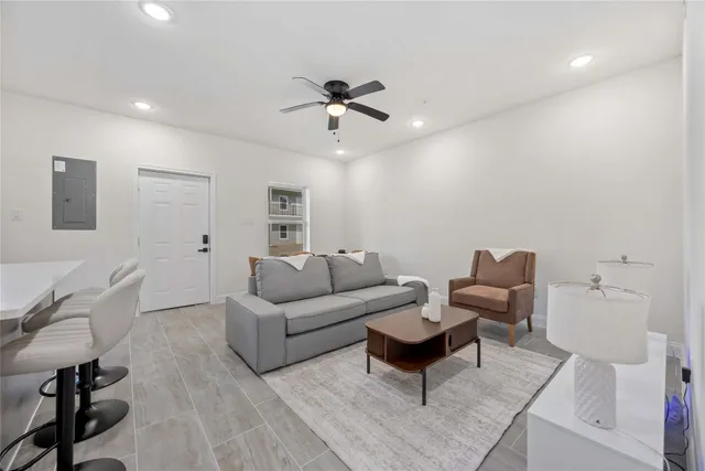 a living room with furniture a ceiling fan and a rug