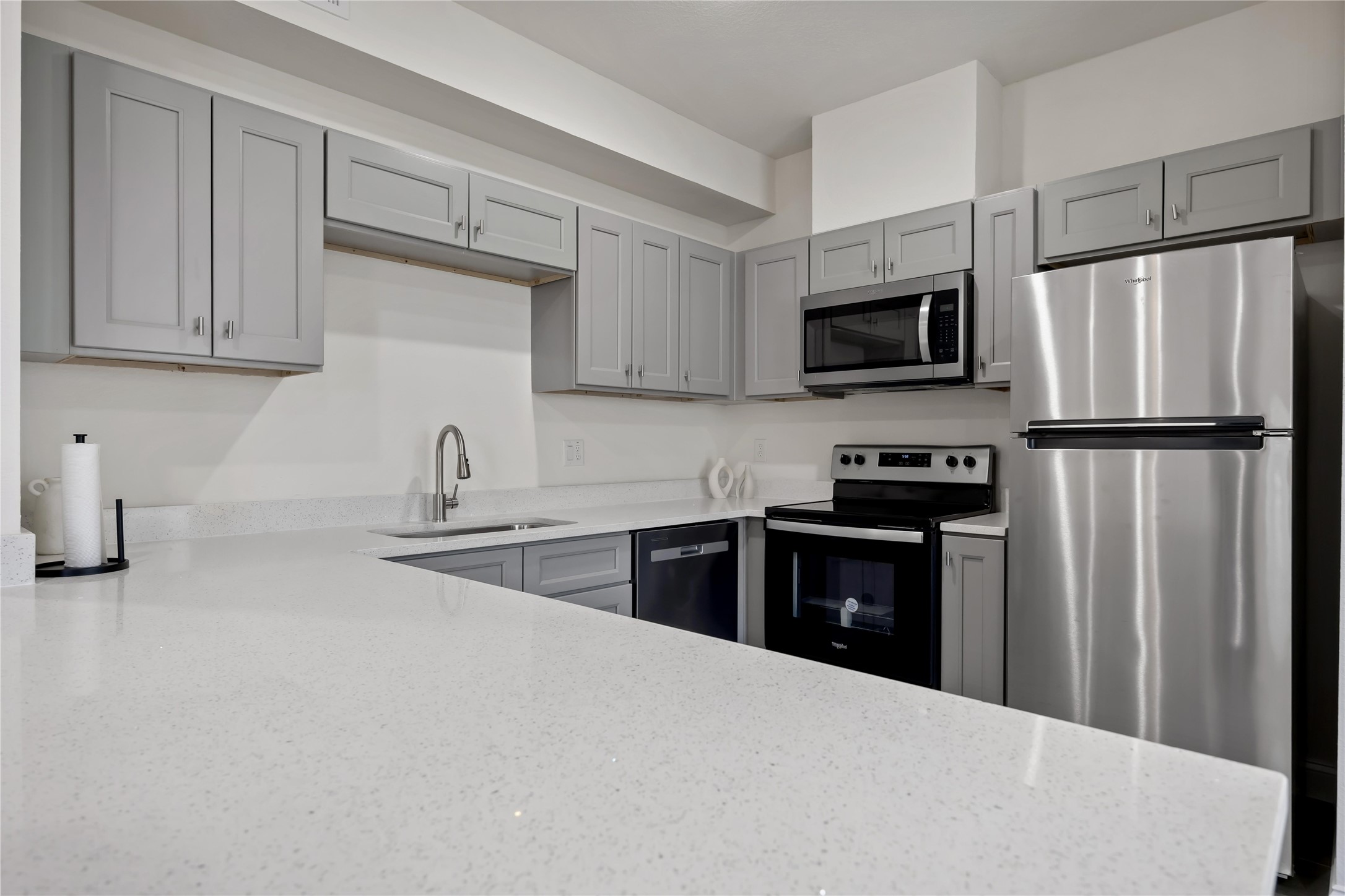 9129 Brandon Street, Unit A7 Houston, TX 77051 - Photo 7 of 15 a kitchen with refrigerator a microwave a sink and cabinets