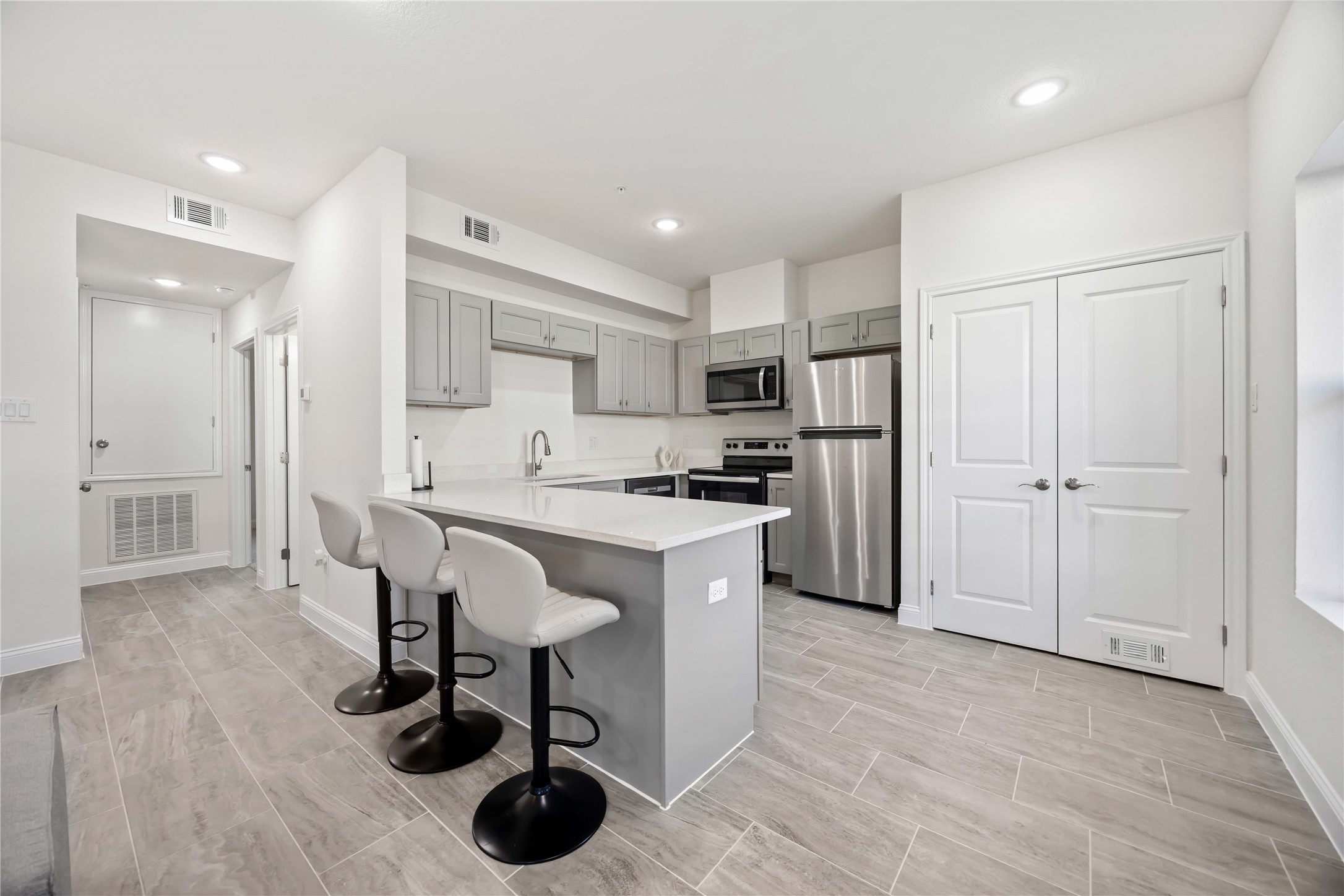 9129 Brandon Street, Unit A7 Houston, TX 77051 - Photo 9 of 15 a kitchen with a refrigerator a sink and a cabinets
