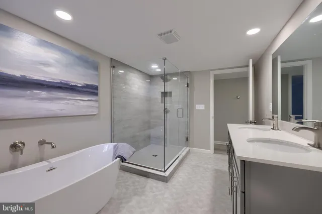 a bathroom with a tub a sink shower and mirror