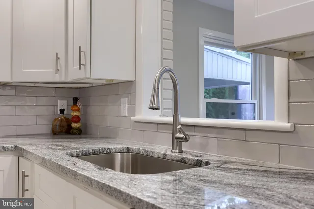 a kitchen with granite countertop a sink and a window