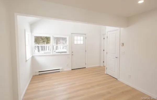 a view of an empty room with wooden floor