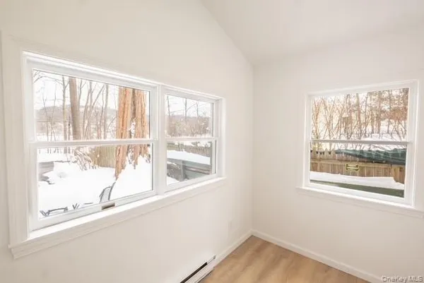 a view of a hallway with wooden floor and closet