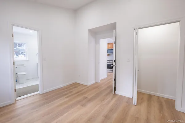 a view of a livingroom with a refrigerator wooden floor and a window