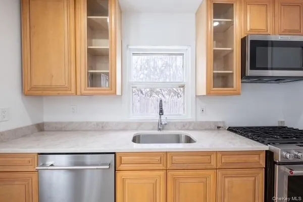 a view of street with house and trees in the background