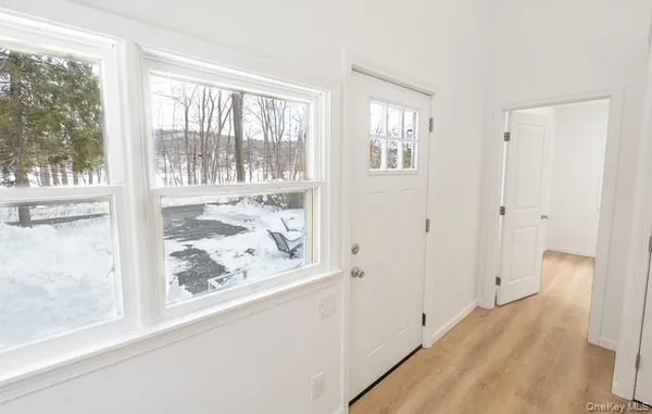 a view of a hallway with wooden floor and closet area