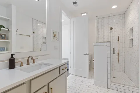 a bathroom with a shower sink and mirror