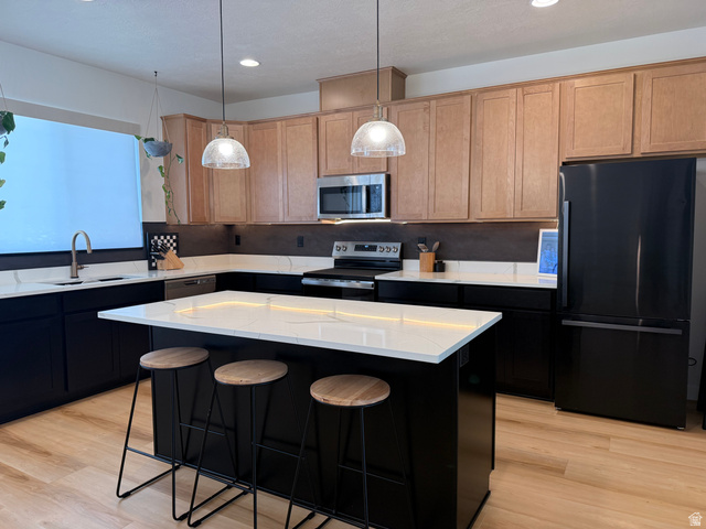 774 West 480 South American Fork, UT 84003 - Photo 27 of 76 Contemporary kitchen featuring a large central island with seating, white countertops, and wood-finish flooring
