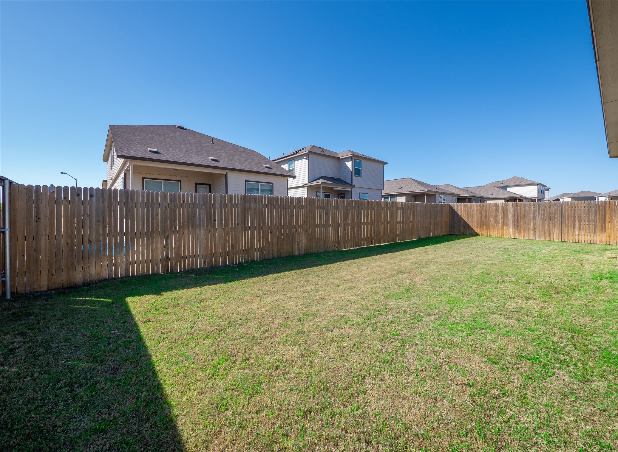 156 Greatest Gift Way Jarrell, TX 76537 - Photo 33 of 40 a view of a house with a yard and a wooden fence