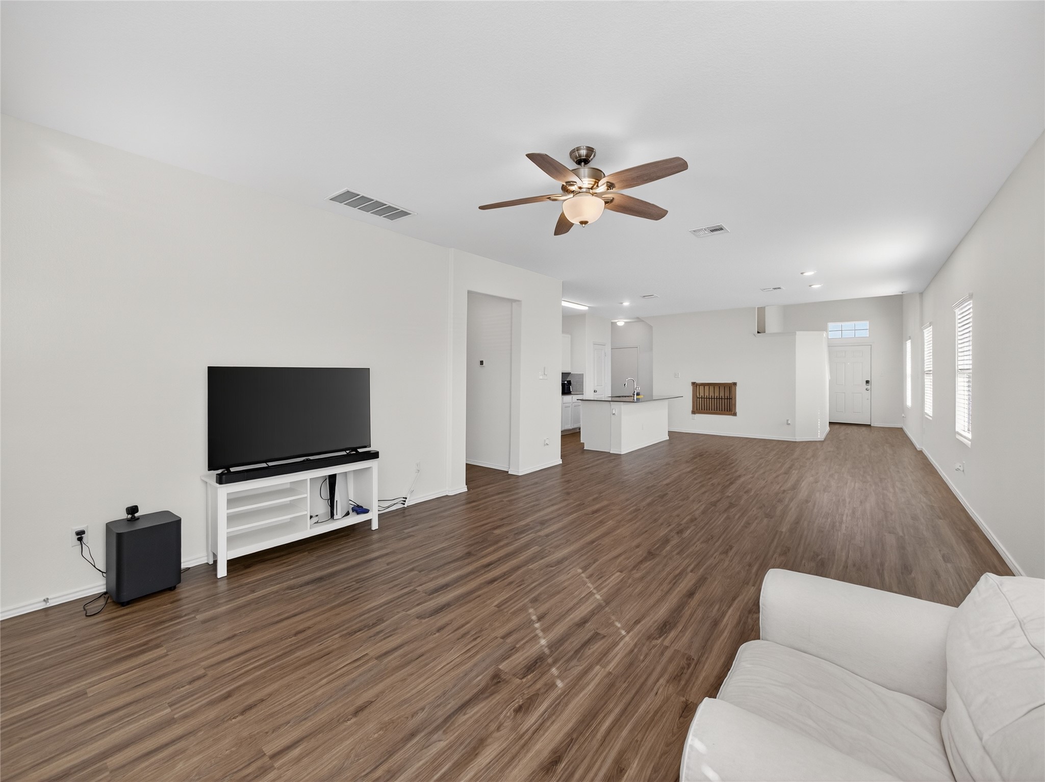 156 Greatest Gift Way Jarrell, TX 76537 - Photo 5 of 40 a view of a livingroom with a flat screen tv wooden floor and a ceiling fan