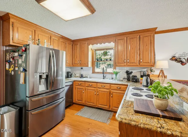 a kitchen with stainless steel appliances granite countertop a refrigerator and a sink