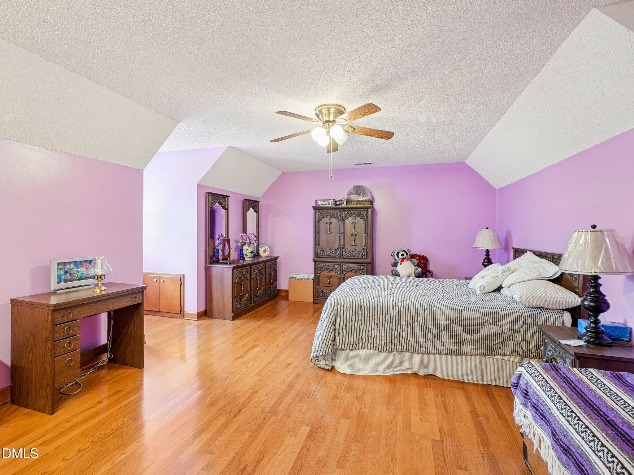750 Stephenson Road Benson, NC 27504 - Photo 9 of 21 a bedroom with a bed and a chandelier