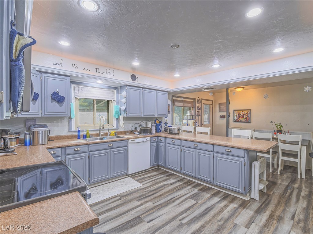 846 Fairview Drive Henderson, NV 89015 - Photo 16 of 39 Kitchen featuring plenty of natural light, light wood-type flooring, a peninsula, recessed lighting, and a textured ceiling