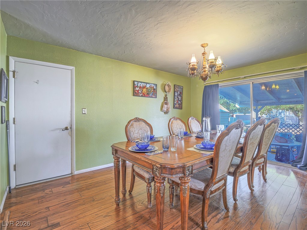 846 Fairview Drive Henderson, NV 89015 - Photo 20 of 39 Dining space featuring hardwood / wood-style flooring, a textured ceiling, a chandelier, and a textured wall