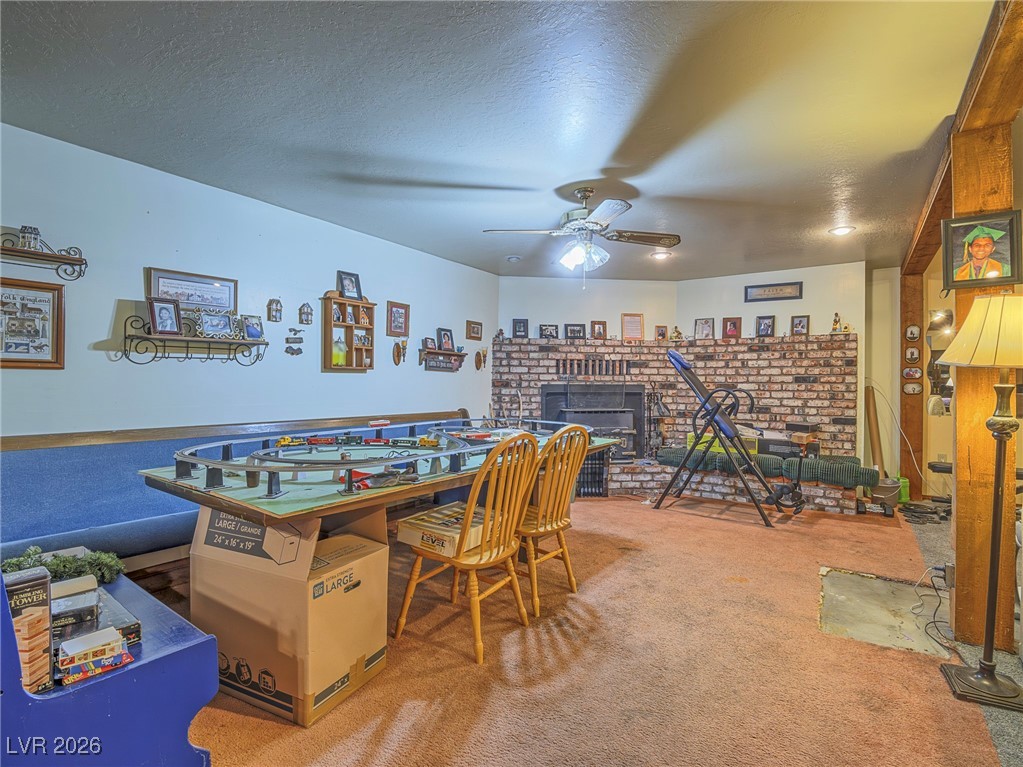 846 Fairview Drive Henderson, NV 89015 - Photo 29 of 39 Playroom featuring carpet floors, a textured ceiling, a fireplace, and a ceiling fan