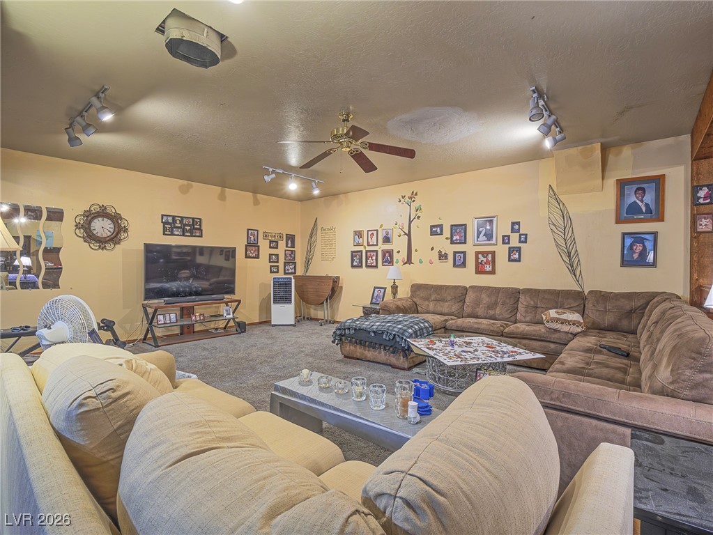 846 Fairview Drive Henderson, NV 89015 - Photo 30 of 39 Living area with rail lighting, carpet floors, a ceiling fan, and a textured ceiling