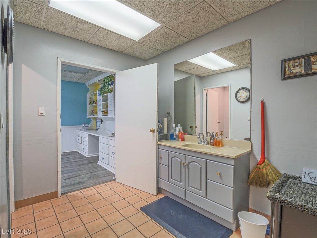 846 Fairview Drive Henderson, NV 89015 - Photo 33 of 39 Bathroom featuring light tile patterned floors, vanity, and a drop ceiling