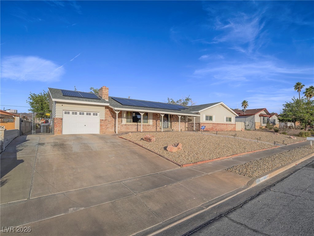 846 Fairview Drive Henderson, NV 89015 - Photo 7 of 39 Single story home with driveway, solar panels, a garage, brick siding, and a chimney