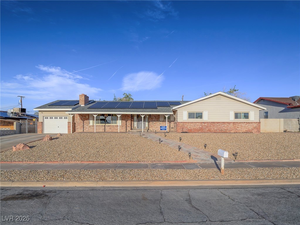846 Fairview Drive Henderson, NV 89015 - Photo 8 of 39 Ranch-style house featuring solar panels, an attached garage, brick siding, a porch, and concrete driveway