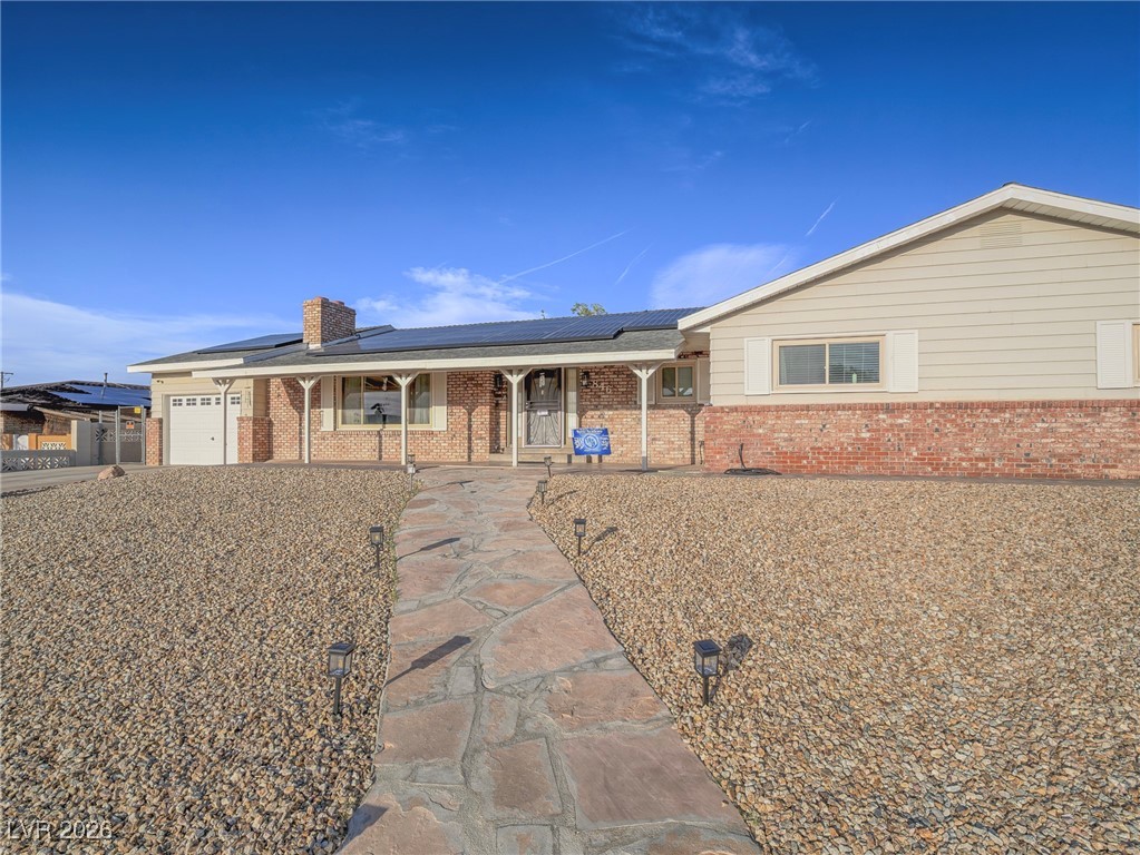 846 Fairview Drive Henderson, NV 89015 - Photo 10 of 39 Ranch-style house featuring solar panels, covered porch, brick siding, and an attached garage