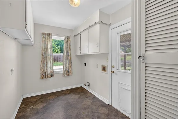a view of empty room with window and cabinet