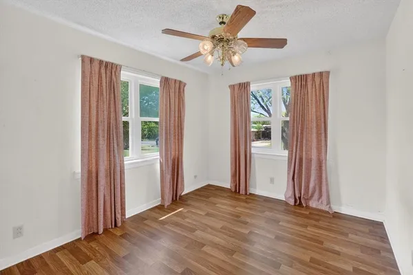 a view of a livingroom with a chandelier fan and windows