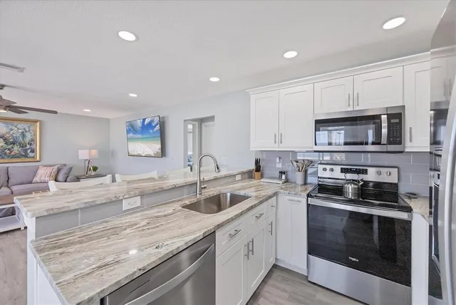 a bathroom with a granite countertop sink a toilet a mirror and shower