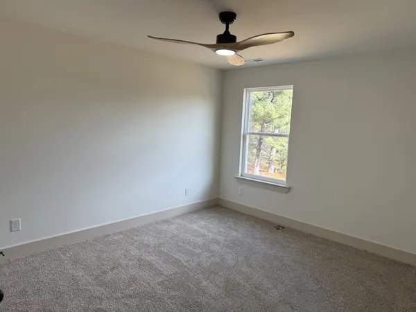 an empty room with a window and a fan