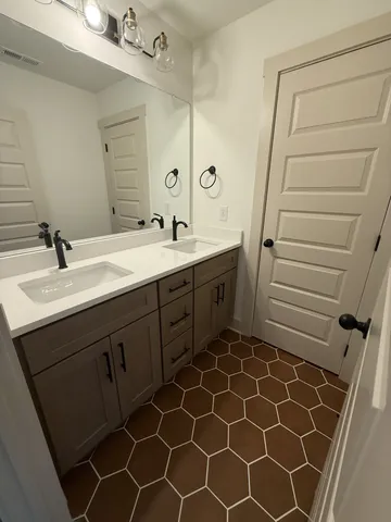 a bathroom with a double vanity sink and a mirror