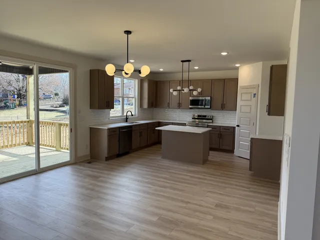 a large kitchen with stainless steel appliances granite countertop a stove and a refrigerator