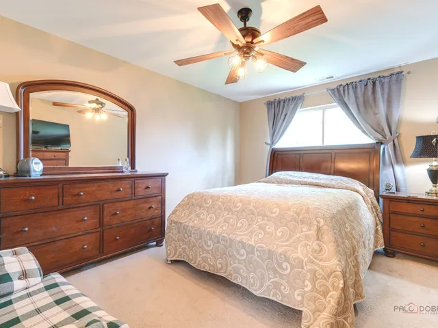 a bedroom with a large bed and a mirror on dresser