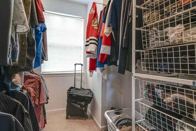 a view of walk in closet with clothes and shoes