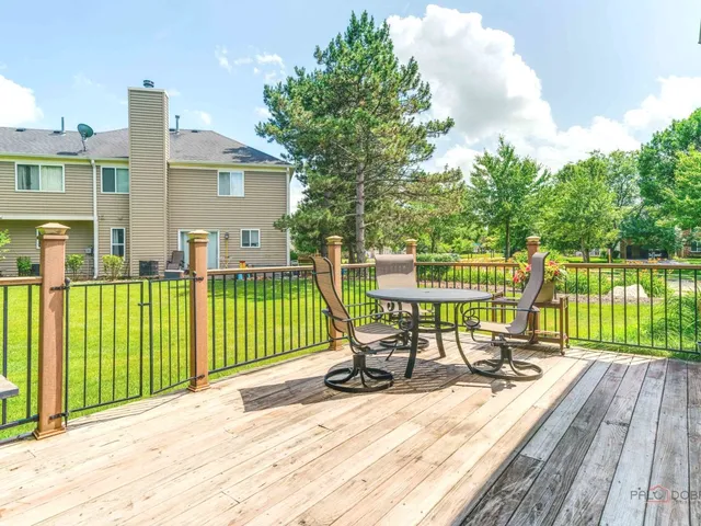 a view of a chair and table on the wooden deck