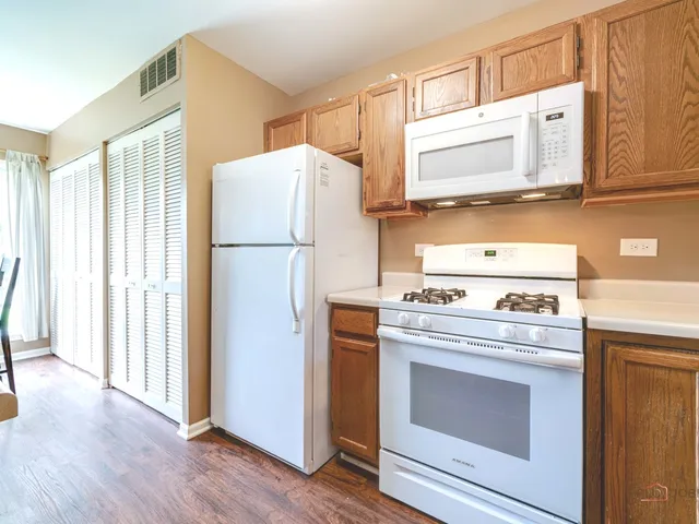 a kitchen with a stove refrigerator and microwave
