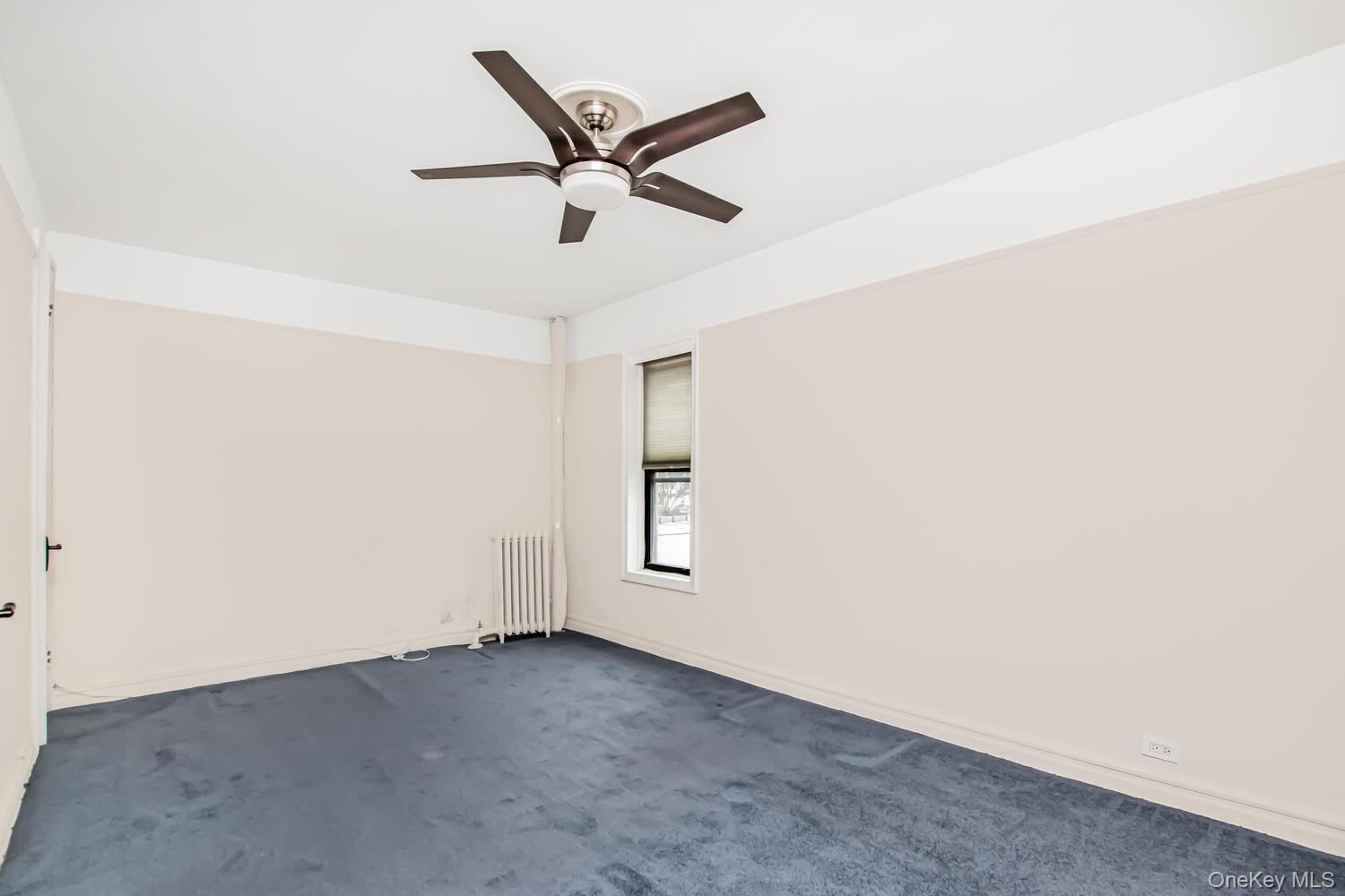 219 Bronx River Road, Unit 5A Yonkers, NY 10704 - Photo 11 of 14 an empty room with a window and a ceiling fan
