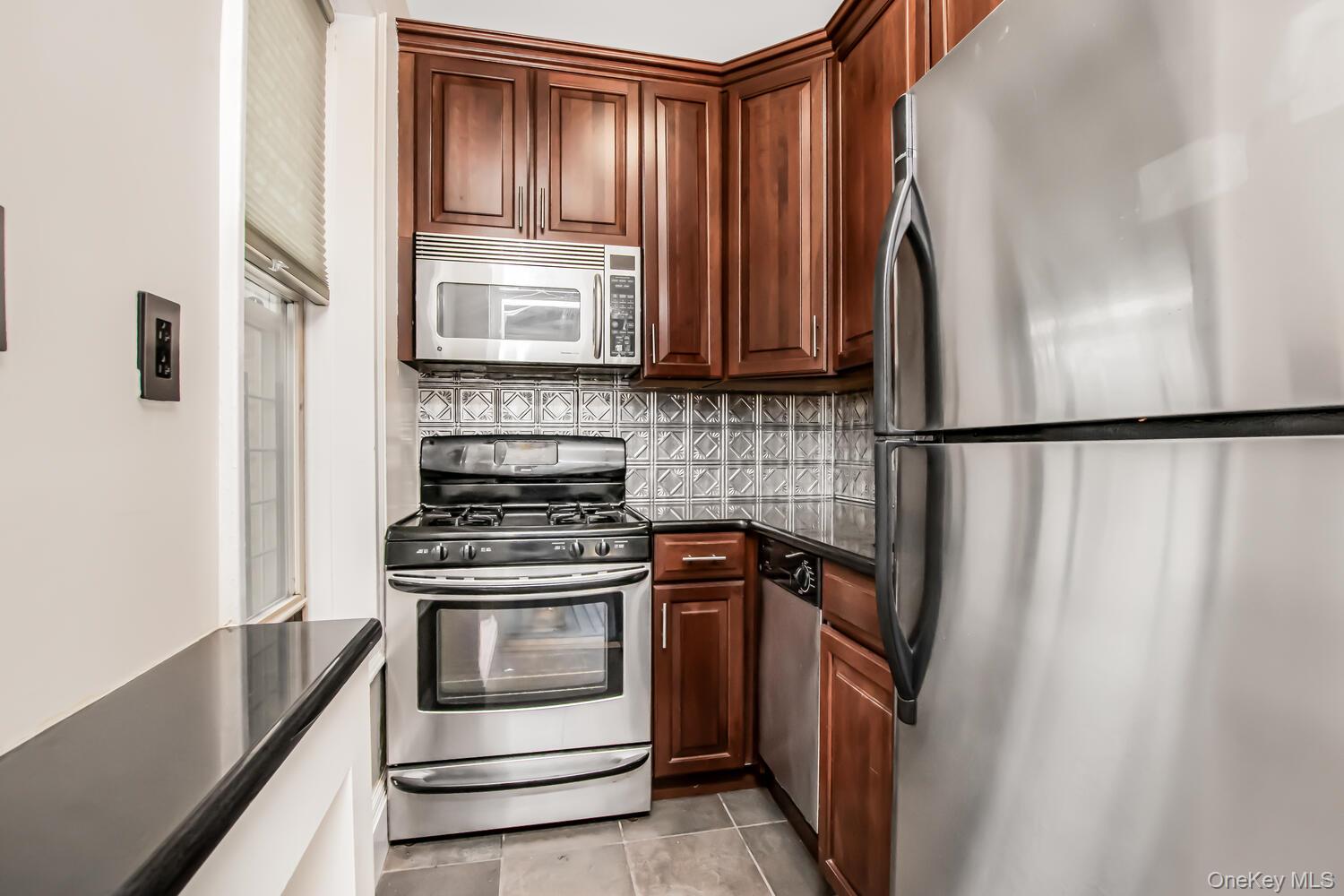 219 Bronx River Road, Unit 5A Yonkers, NY 10704 - Photo 6 of 14 a kitchen with a stove a fridge and a sink