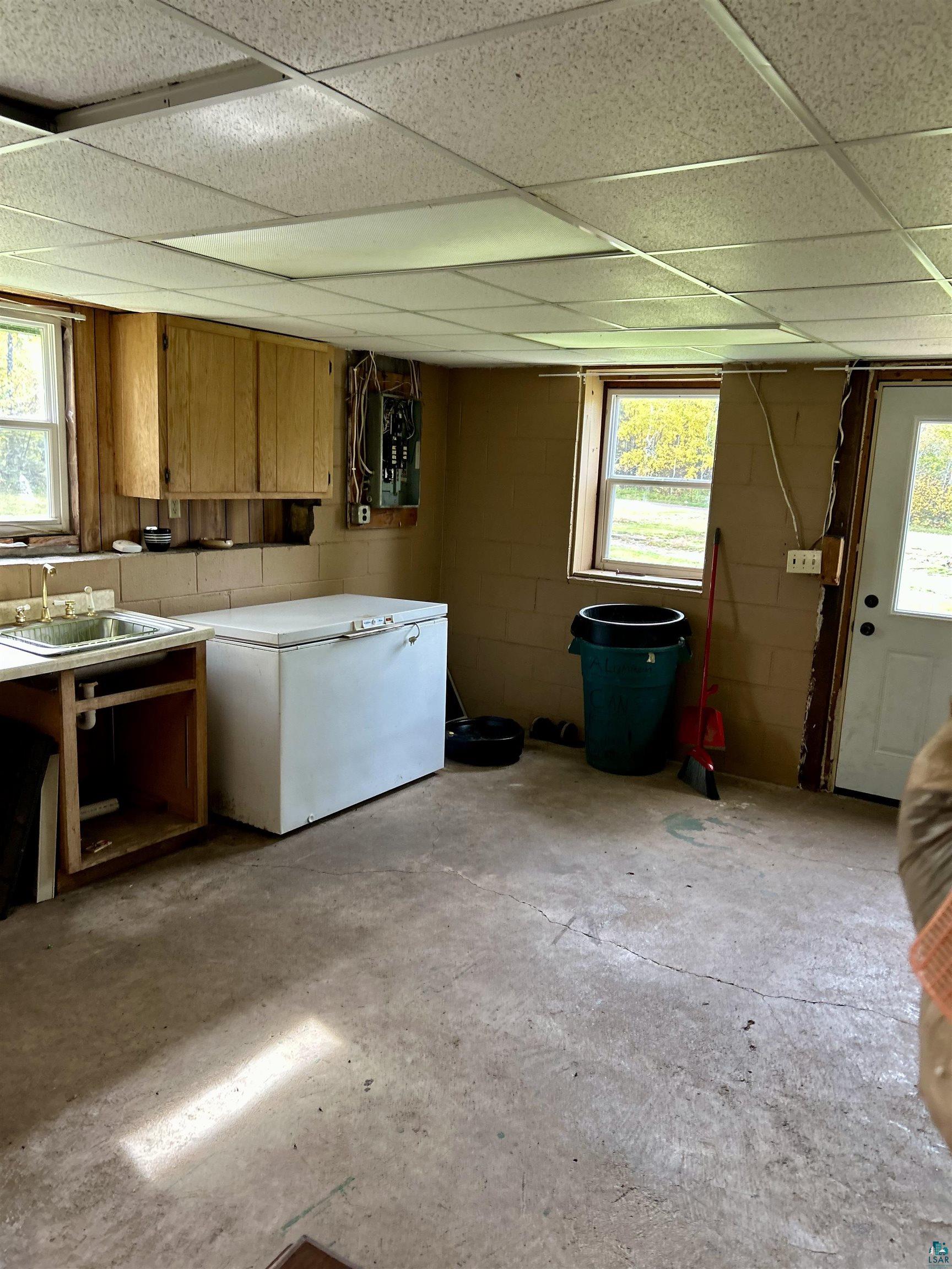 4184 Bergstrom Road Two Harbors, MN 55616 - Photo 8 of 20 Kitchen with brown cabinets, concrete floors, a paneled ceiling, and light countertops