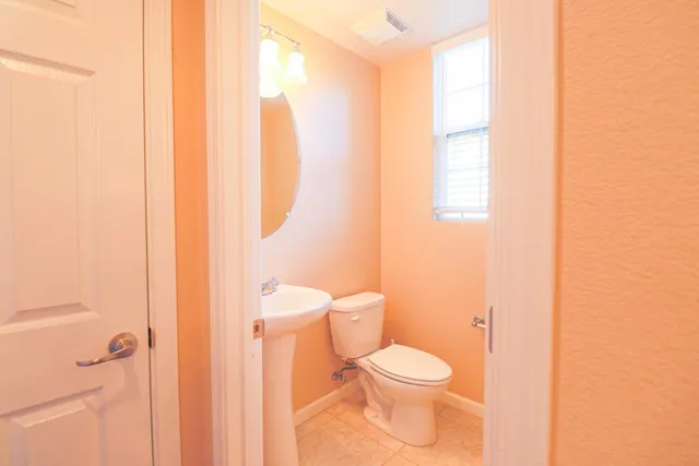 a white toilet sitting next to a bathroom sink