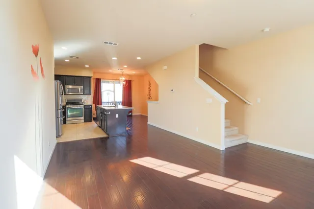 a view of a living room with kitchen view and wooden floor
