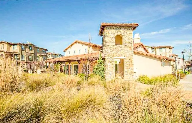 a yellow house with a trees in front of it