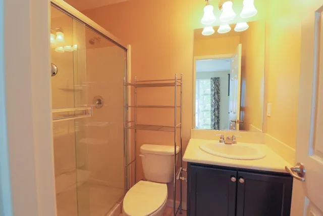 a bathroom with a sink vanity mirror and toilet