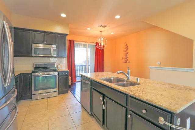 a kitchen with stainless steel appliances granite countertop a sink stove and refrigerator