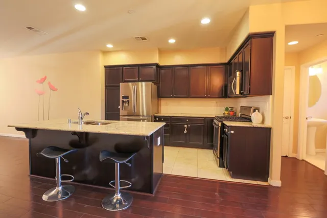 a kitchen with a sink cabinets and wooden floor