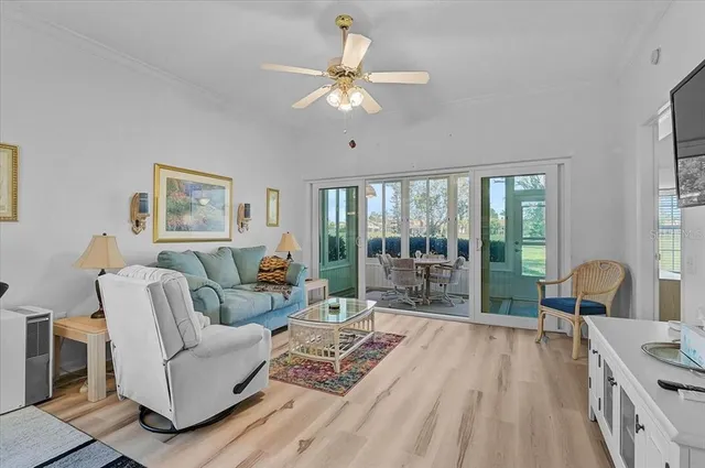 a living room with furniture a flat screen tv and a floor to ceiling window