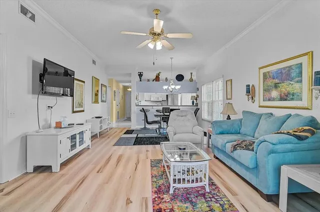 a living room with furniture a chandelier and a flat screen tv
