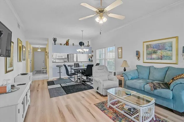 a dining room with furniture a chandelier and wooden floor