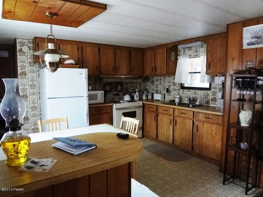 69 Salem Heights Rd Lake Lake Ariel, PA 18436 - Photo 11 of 18 a kitchen with a sink a stove and chairs