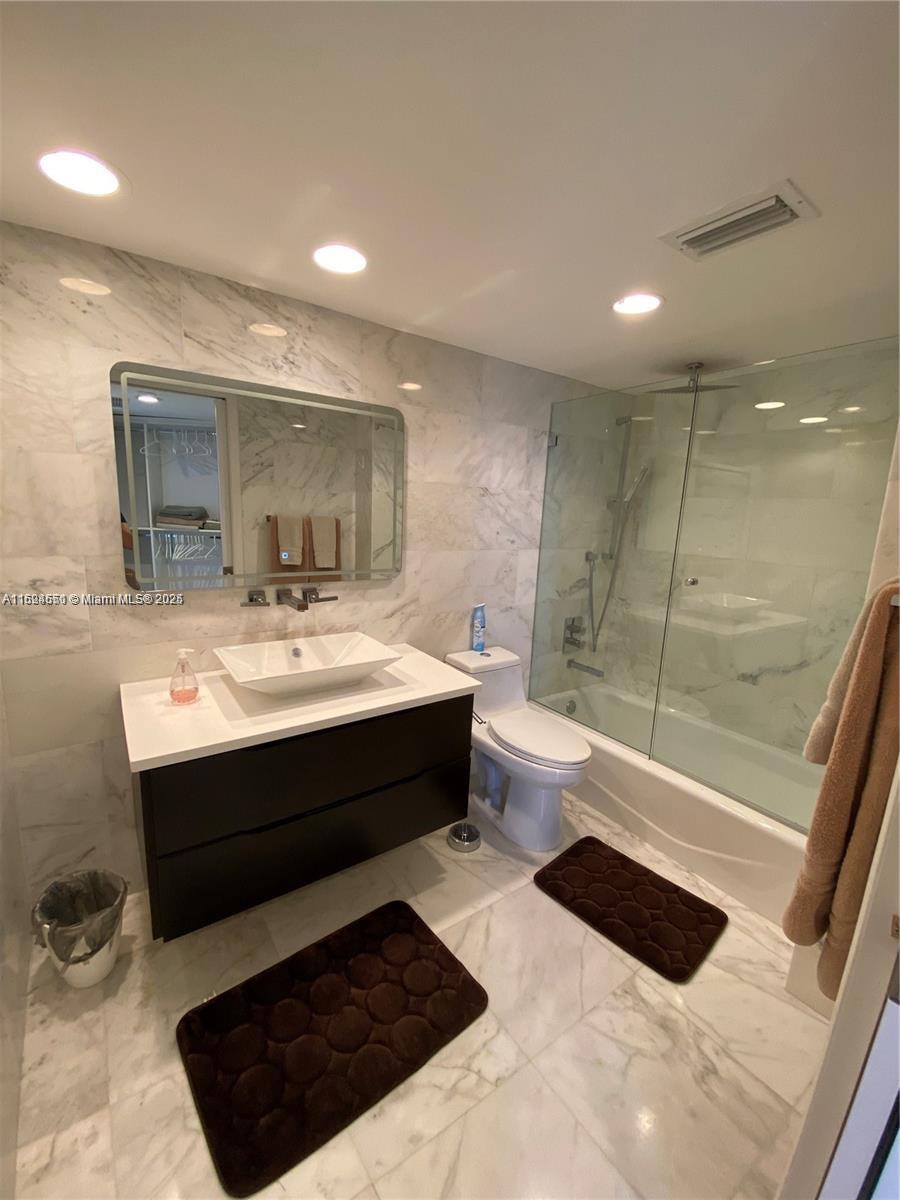 2800 North Ocean Drive, Unit B15C Riviera Beach, FL 33404 - Photo 14 of 32 a bathroom with a sink a toilet a mirror and shower