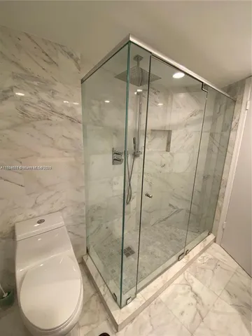 a bathroom with a toilet and a shower