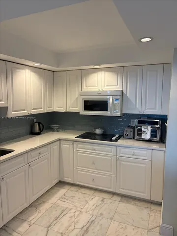 a kitchen with white cabinets a sink and dishwasher